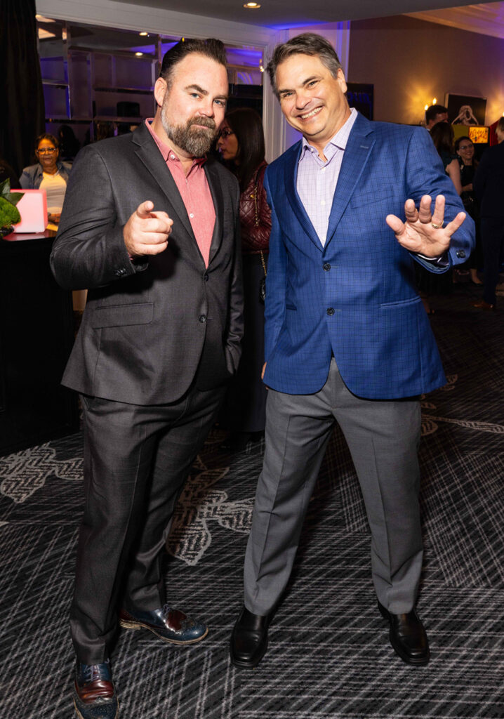 Two men in formal attire mugging for the camera.