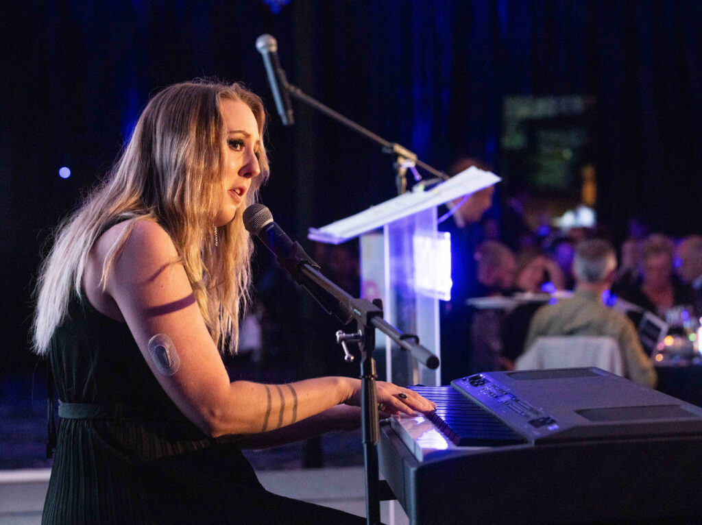 ResurrectionFern playing an electronic piano and singing, in front of the Gala audience.