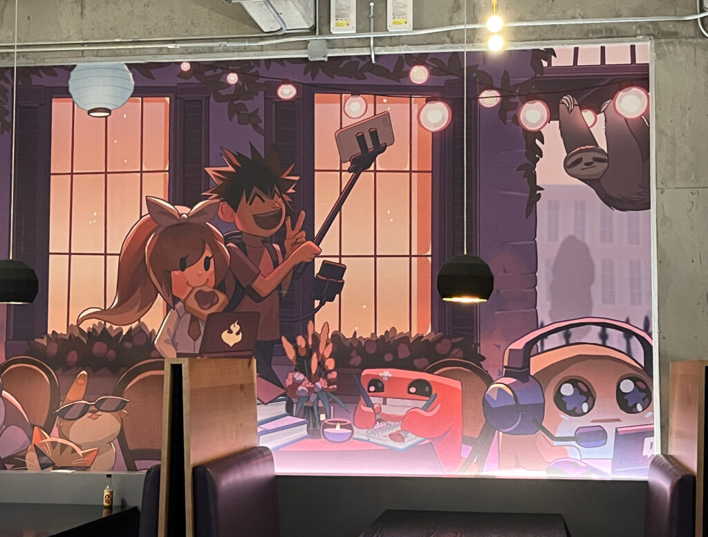 Mural on the cafeteria wall featuring Meat Boy and other game characters.