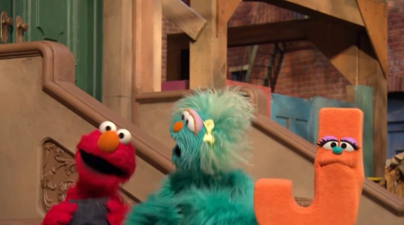 Screen grab from Sesame Street: Episode #4306: The Letter J Song -- Muppets Elmo and Rosita singing with a frowning letter J